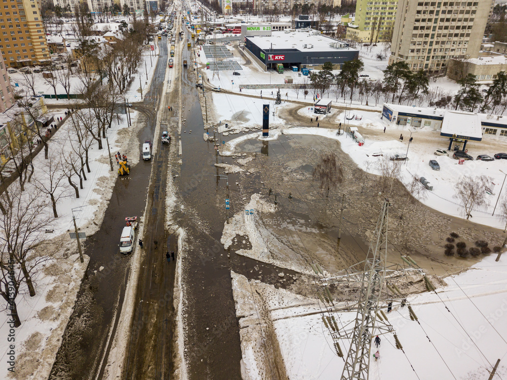 Pipeline failure in the city. Aerial drone view. Winter snowy morning.