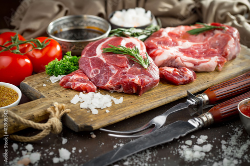 Raw meat with spices in a composition with kitchen accessories.