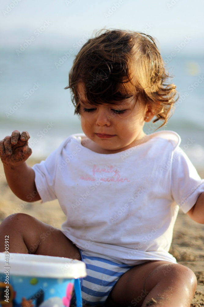 portrait of a girl on the beach playing with sand portrait of a girl on the beach playing with sand