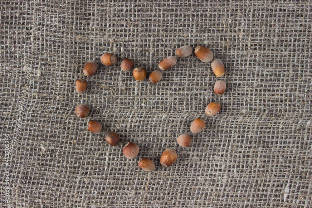 Nuts laid out in the shape of a heart on burlap. Organic, healthy food, ecology, farm Nuts laid out in the shape of a heart on burlap. Organic, healthy food, ecology, farm