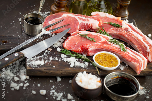 Raw meat with spices in a composition with kitchen accessories.