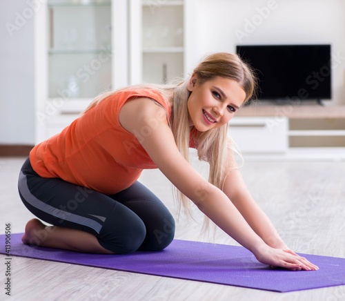 Pregnant woman doing sport exercise at home