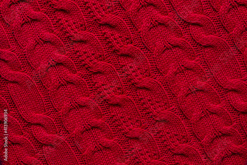 The texture of a red knitted sweater. Textured background knitting.