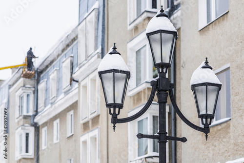 Drohobych, UKRAINE - FEBRUARY 10, 2021: Street lights on city streets, winter time, snow on lantern.