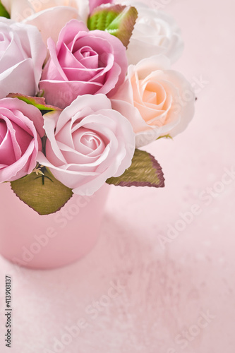 Festive composition with beautiful delicate roses flowers in pink round box on light pink background. Flat lay  copy space. Greeting card.