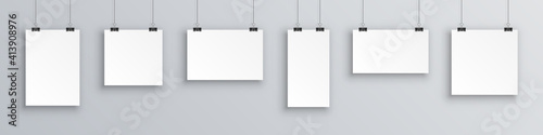 Mock up hanging empty white paper blank. Concept gallery portfolio, photo frame paper, poster. Creative of blank posters hanging list with shadows. Hanging white paper on binders, sheet on wall