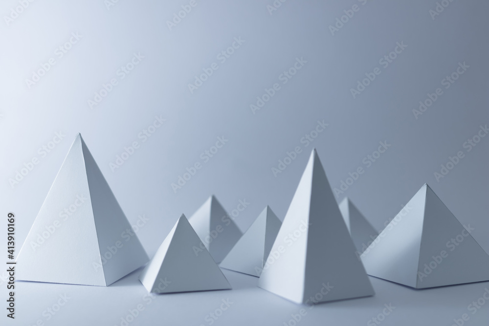 white 3d handmade pyramids on white background, selective focus white 3d handmade pyramids on white background, selective focus
