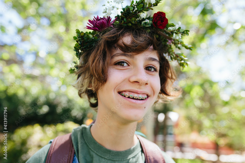 Smiling teen with braces wears a flower crown outside Smiling teen with braces wears a flower crown outside