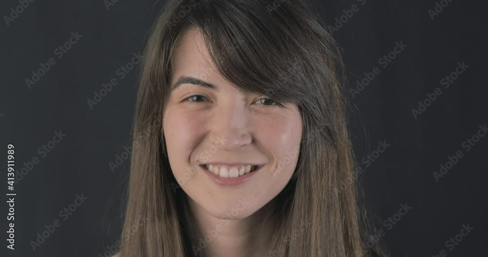 Pure face young beautiful woman smiling shy. naive and happiness concept on black background, slow motion. Pure face young beautiful woman smiling shy. naive and happiness concept on black background, slow motion.