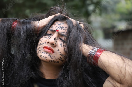Photography A southeast Asian brown woman protesting gender based violence by writing anti v