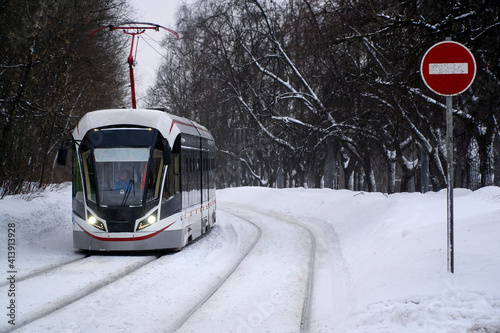 Tram in winter among snow in Moscow Sokolniki park