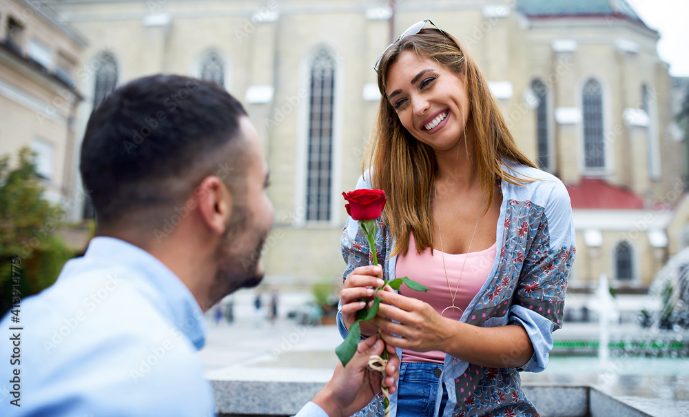 Young man surprised his girlfriend with a red rose. Love and relationships Young man surprised his girlfriend with a red rose. Love and relationships