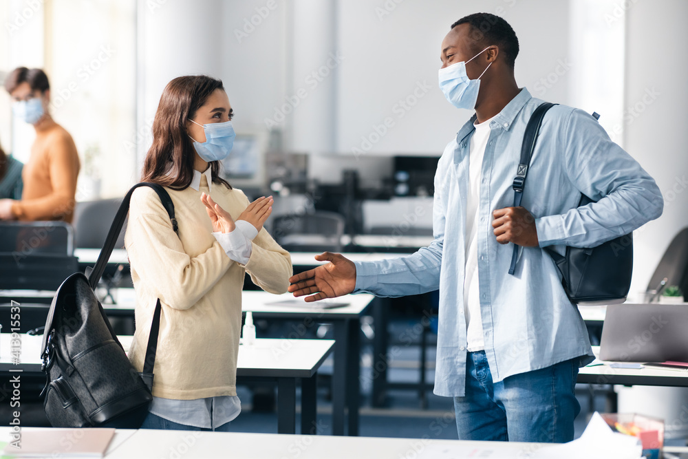 Fototapeta premium Woman rejects touching, showing stop sign gesture to handshake