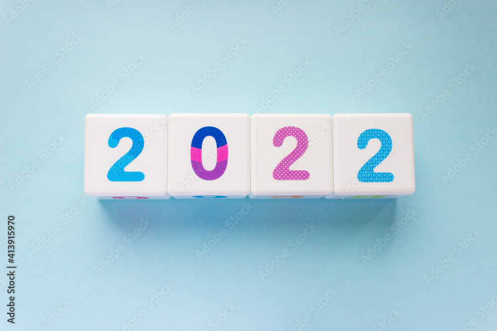 Cubes with colorful numbers 2022 on blue background. New year, calendar. Figures in a row Cubes with colorful numbers 2022 on blue background. New year, calendar. Figures in a row