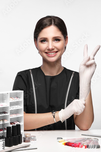 Obraz na płótnie Manicurist in working form with tools in hand. Nail photo content