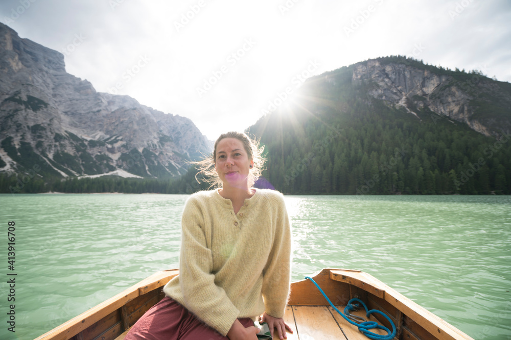 Woman sitting in boat on river amidst mountain against sky Woman sitting in boat on river amidst mountain against sky
