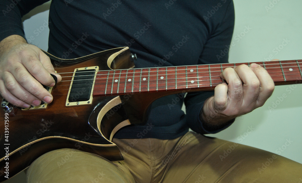 Homem sentado a tocar guitarra eléctrica de caixa oca ao estilo jazz e blues - a executar um solo Homem sentado a tocar guitarra eléctrica de caixa oca ao estilo jazz e blues - a executar um solo