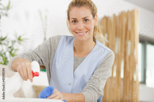 Bild auf Leinwand beautiful young housekeeper cleaning and washing kitchen