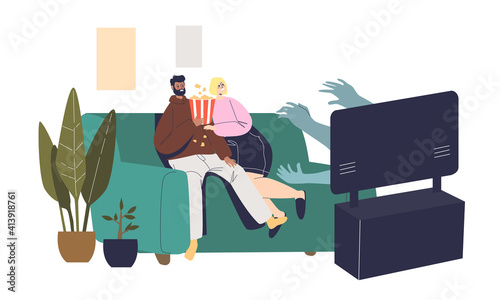 Couple watching horror movie on tv at home sitting frightened on couch in living room