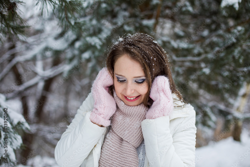 Woman look down and miles under the snow covered tree Woman look down and miles under the snow covered tree