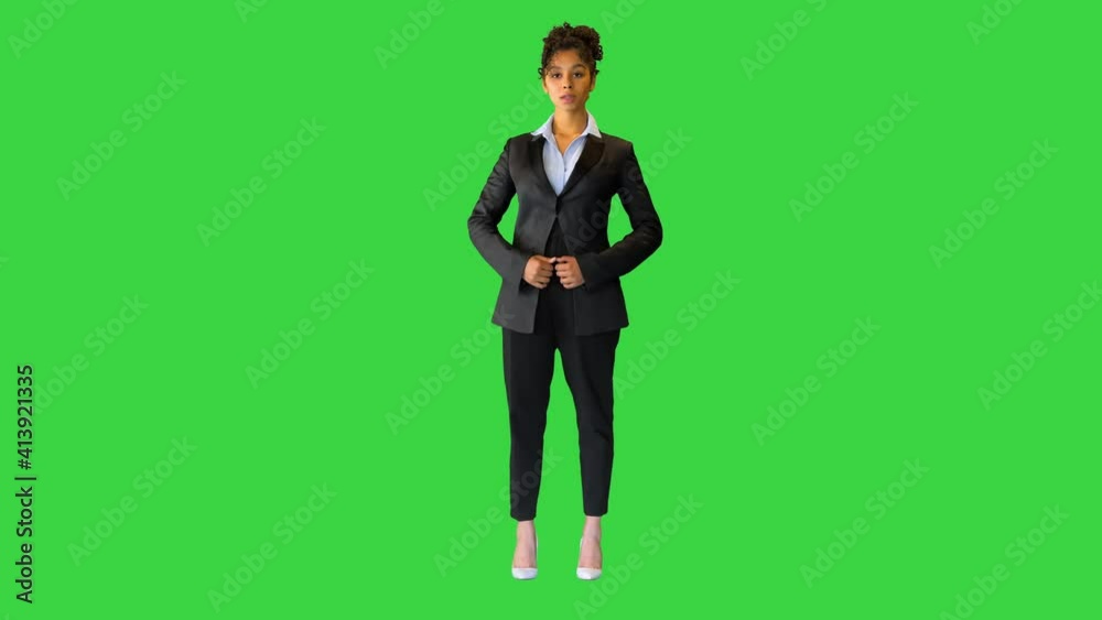 Joyful black lady adjusting her jacket and looking into the camera on a Green Screen, Chroma Key. Joyful black lady adjusting her jacket and looking into the camera on a Green Screen, Chroma Key.
