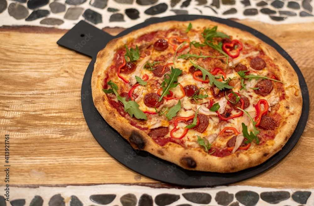 pizza, salami and rockets on a wooden board