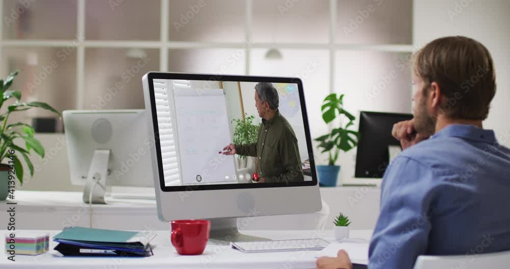 Caucasian male student using computer on video call with male teacher