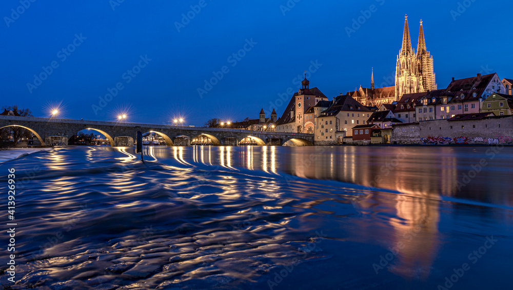 Regensburg bei Hochwasser in der blauen Stunde mit dem Dom St. Peter und der Steinernen Brücke