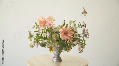 Jarrón plateado con diversas flores. Girasoles. Orquídeas