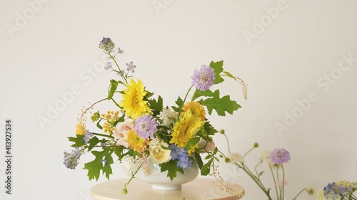 Arreglo floral de jarra blanca sobre una mesa