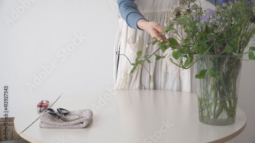Mujer arreglando el jarrón de plantas