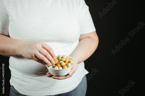 Overweight woman overeating sugary snacks