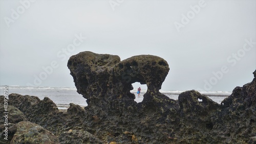 Roca sobre la playa y hombre a lo lejos © Zebaite