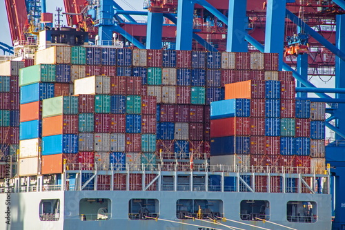 Foto Container ship with colorful containers on the vessel quayside in the freight te