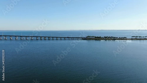 Wallpaper Mural Aerial Drone Push In Dolly Shot Over Blue Bay Water and Palm Trees Towards Bridge Traffic and Skyline in the Distance.  Late Afternoon and Palm Trees are Silhouetted.  Clearwater Memorial Causeway FL Torontodigital.ca