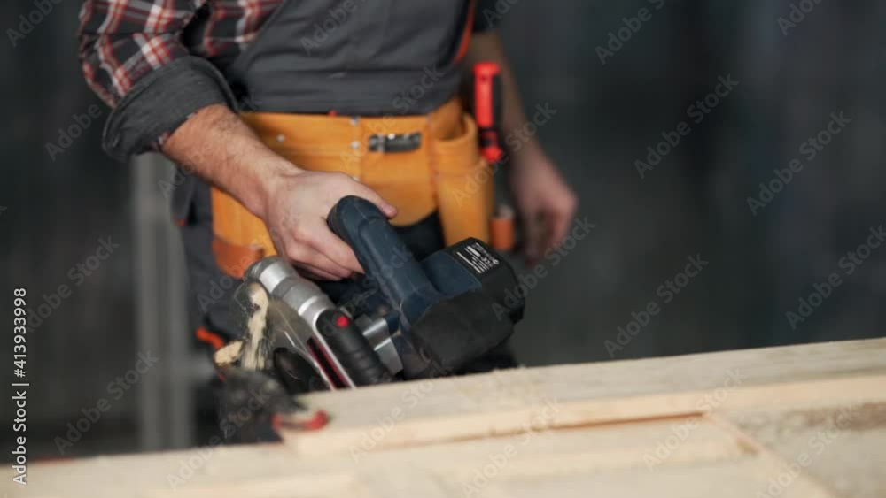 Close-up of a hand-held electric saw in the hands of a carpenter Close-up of a hand-held electric saw in the hands of a carpenter