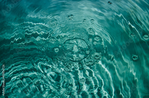 Swimming pool water background with drops and bubbles in tidewater green color.