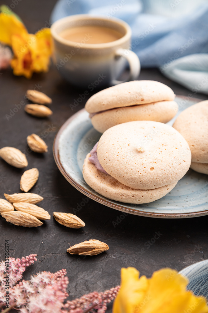 Meringues cakes with cup of coffee on a black concrete background. Side view, selective focus. Meringues cakes with cup of coffee on a black concrete background. Side view, selective focus.