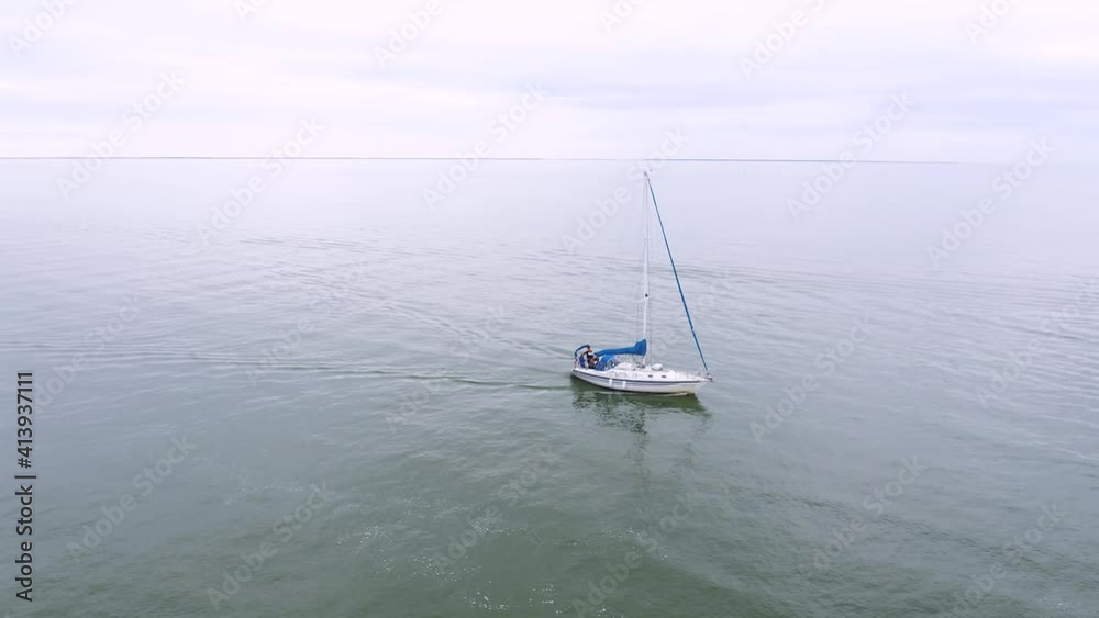 Lone sailboat out in the ocean on its way in to harbor. Aerial circling shot. Lone sailboat out in the ocean on its way in to harbor. Aerial circling shot.