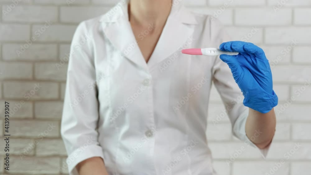 The doctor shows a pregnancy test. The doctor shows a pregnancy test.