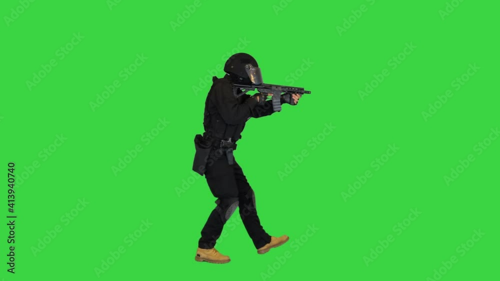 Anti terrorist unit policeman walking and aiming with a rifle on a Green Screen, Chroma Key. Anti terrorist unit policeman walking and aiming with a rifle on a Green Screen, Chroma Key.