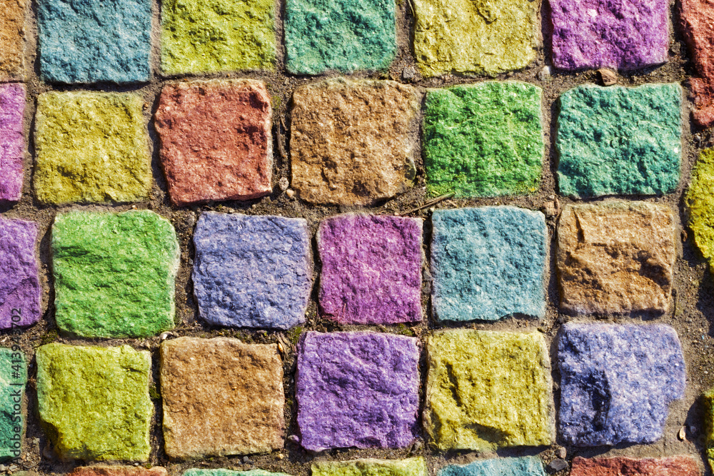 square bricks painted in various colors, with an uneven surface, between which the earth and sand square bricks painted in various colors, with an uneven surface, between which the earth and sand