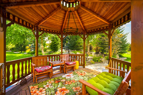 View of a wooden gazebo in the landscaped garden of an upscale home. photo