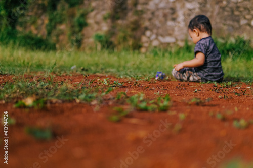 a boy is playing on the dirty ground