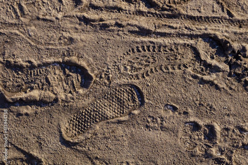 top view of footprints of human shoes in the sand