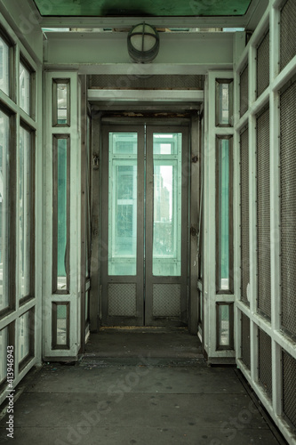 Bright abstract tunnel with elevator door centered with blue and green tones © Mark