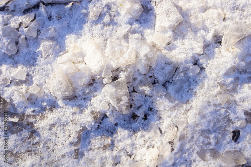 fine snow mixed with ice fragments and stones illuminated by the rays of the sun