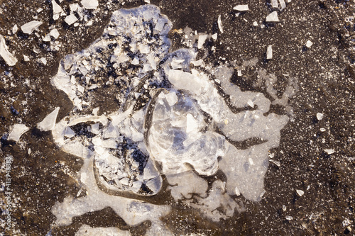 a puddle froze over the ground, and the top layer with an air bag was broken