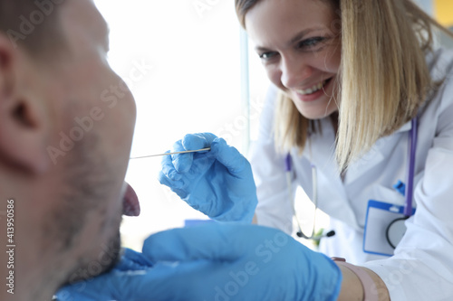 Otorhinolaryngologist examines patient s throat in office closeup