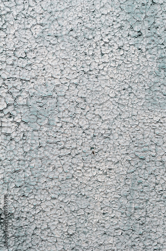 Old faded background, cracked white paint on the wall, surface with cracks